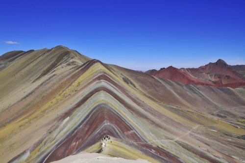 a painting of a mountain with colorful hills at Hostal Inca in San Pedro