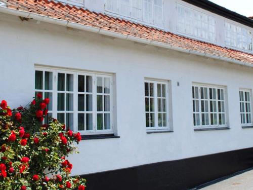 a white house with a christmas tree in front of it at 4 person holiday home in Svaneke in Svaneke