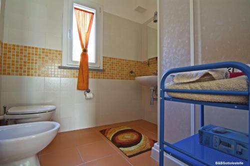 a bathroom with a sink and a toilet and a window at B&B Sotto le Stelle in Fano