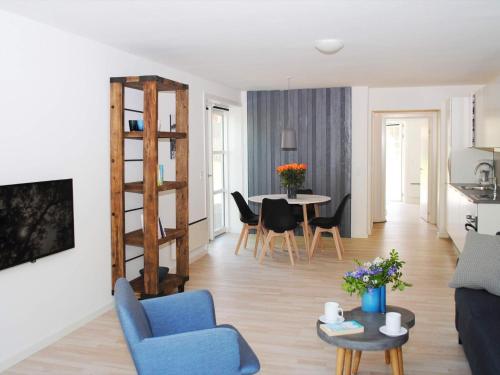a living room with a blue couch and a table at 4 person holiday home in Allinge in Allinge