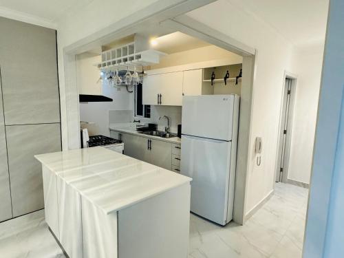 uma cozinha branca com um frigorífico e uma bancada em Best Place Cayenas 7 em La Grúa