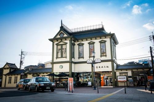 a building with a clock on the top of it at 南町駅徒歩2分 松山城や道後温泉へ好アクセス 一軒家貸切り和の家 11人まで 駐車場無料 in Matsuyama