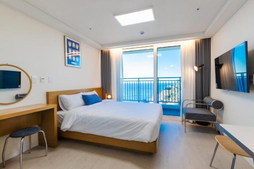 a bedroom with a bed and a large window at Blue12 Yangyang Surf in Yangyang