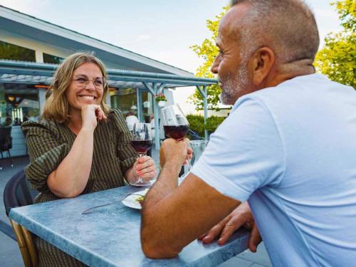 un hombre y una mujer sentados en una mesa con copas de vino en 2 person holiday home in Allinge, en Allinge