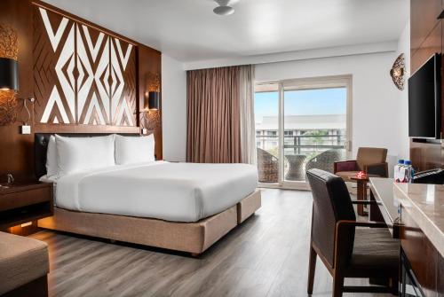a hotel room with a large bed and a desk and a desk at Crowne Plaza Fiji Nadi Bay Resort & Spa by IHG in Nadi