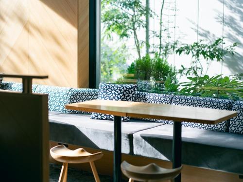 a table and chairs in a room with a window at Kaname Inn Tatemachi in Kanazawa