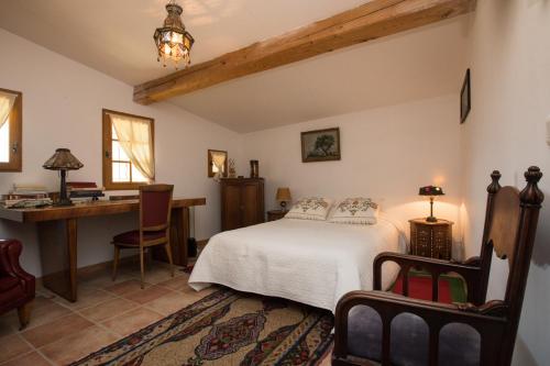 - une chambre avec un lit et un bureau dans l'établissement Villa Paradis, à Saint Antonin du Var
