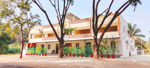 a building with trees in front of it at AYYAN RESIDENCY in Alāndurai