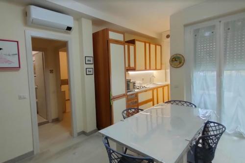 eine Küche und ein Esszimmer mit einem weißen Tisch und Stühlen in der Unterkunft CASA GILIANA al mare in Fiumaretta di Ameglia