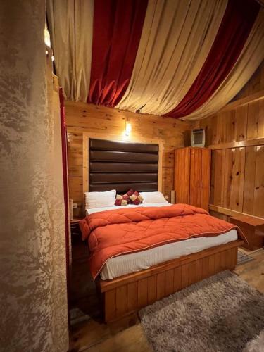 a bedroom with a bed with a red comforter at Junga Retreat and Tree House by StayApart in Chail