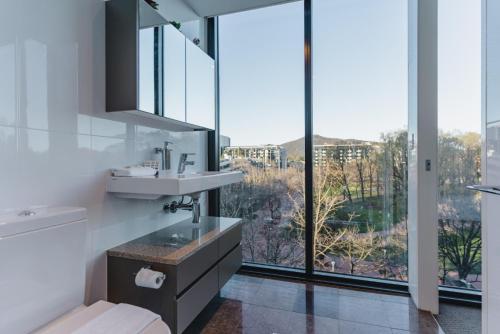 a bathroom with a sink and a large window at Central Located 2-Bed with Pool, Gym & Parking in Canberra