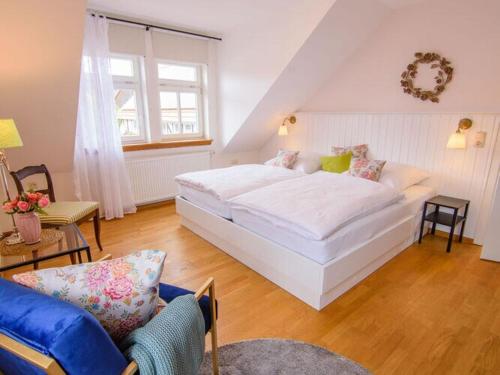 a bedroom with a large white bed and a couch at WERTS HOF Apartment 2 