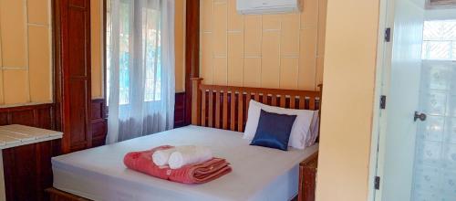 a small bedroom with a bed with towels on it at Bon Tai Oasis Bungalows in Muang Không