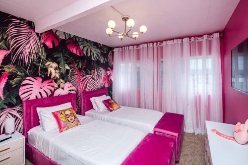 twee bedden in een kamer met roze muren en planten bij Bella Cactus - Palm Springs Vibes Pool & Spa in Lake Havasu City
