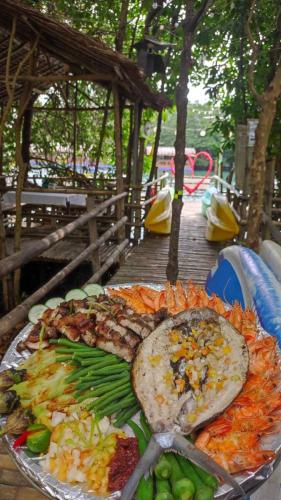 Virgin River Resort and Recreation Spot في Bolinao: طبق من الطعام على طاولة مع الطعام