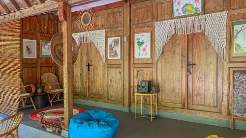 a room with wood paneled walls and a room with a table and chairs at Yukke Tembi Homestay in Yogyakarta