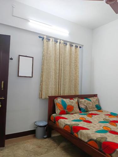 a bedroom with a bed and a window at AYYAN RESIDENCY in Alāndurai