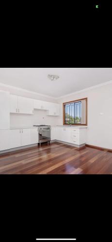 an empty room with a kitchen and a window at 68 Frederick in Sydney