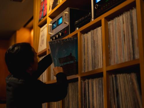 a person is looking at a album on a shelf at Kaname Inn Tatemachi in Kanazawa