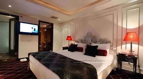 a bedroom with a large bed and a flat screen tv at Super Nile Cruise LUXOR & ASWAN in Luxor