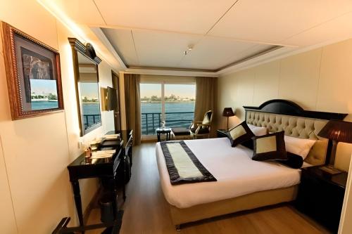 Super Nile Cruise LUXOR & ASWAN في الأقصر: غرفه فندقيه بسرير ومكتب ونافذه