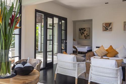 a living room with chairs and a couch and a table at Martini Suite and Villa in Kerobokan