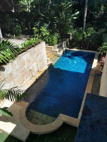 a swimming pool with blue water in a backyard at Martini Suite and Villa in Kerobokan