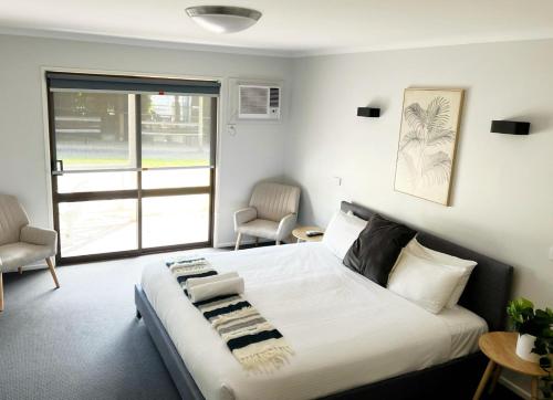 Un dormitorio con una gran cama blanca y una ventana en Lake Hume Resort, en Lake Hume