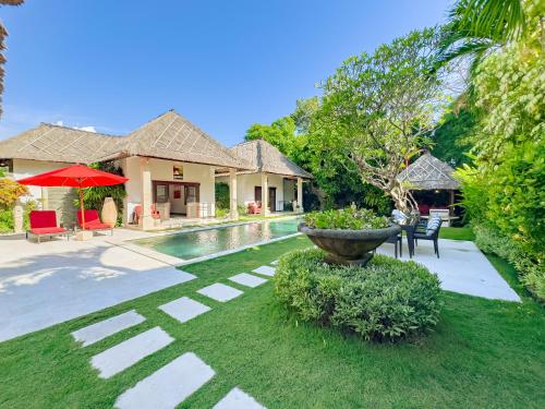 a house with a pool and a yard with a fountain at Villa Bugis Abimanyu Seminyak in Seminyak