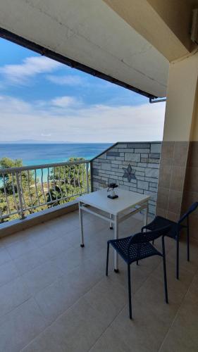 ein weißer Tisch und Stühle auf einem Balkon mit Blick auf das Meer in der Unterkunft NIKOS SEA VIEW ROOM in Kallithea (Chalkidiki)