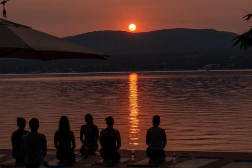 a group of people sitting on the beach watching the sunset at Airam, Holistic Boutique Hotel in Tequesquitengo