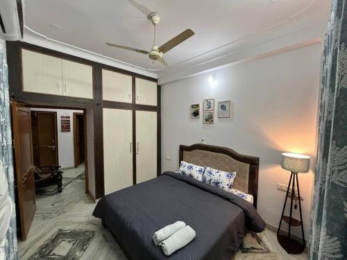 een slaapkamer met een bed en een plafondventilator bij The Cozy Nook in Udaipur