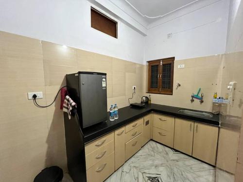 een grote keuken met een wastafel en een koelkast bij The Cozy Nook in Udaipur