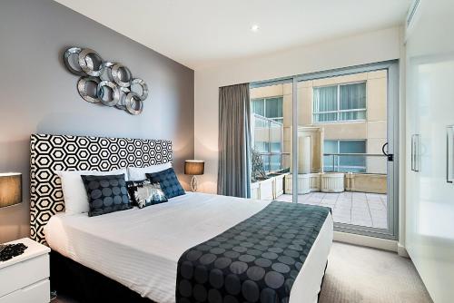 a bedroom with a large bed and a large window at Glenelg Beachfront Luxury Apartment in Glenelg