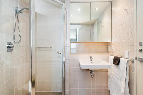 a bathroom with a sink and a shower at Glenelg Beachfront Luxury Apartment in Glenelg