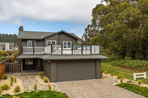 uma casa com uma varanda e uma garagem em Seaside Haven Modern Retreat with Breathtaking Views and Beachside Charm em Half Moon Bay