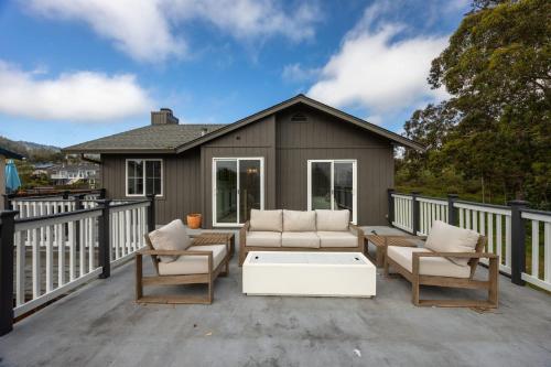 a patio with two couches and a coffee table at Seaside Home Modern Retreat with Breathtaking Views and Beachside Charm in Half Moon Bay