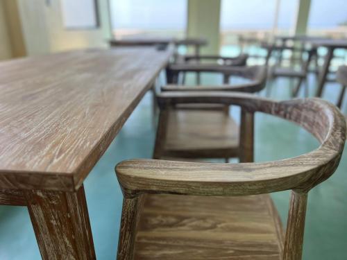 a wooden table and chairs in a room at Isla Retreat in Fehendhoo