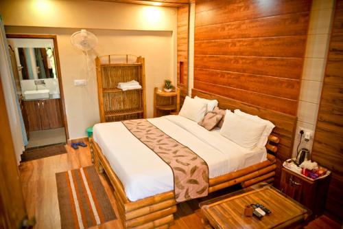 1 dormitorio con 1 cama en una habitación con paredes de madera en The Palash Vann Resort Madhya Pradesh, en Silāri
