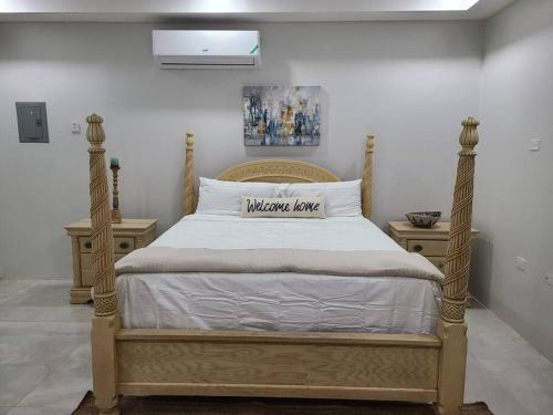 a bed with a wooden frame in a bedroom at Beachscape At Black River Ethlyn by the sea in Black River