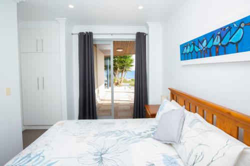 a bedroom with a bed and a view of the ocean at Shearwaters Apartment Waterfront Accomodation in Penneshaw