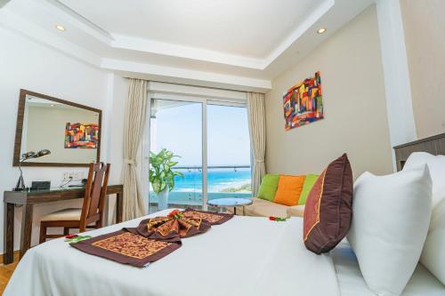 a bedroom with a bed with a view of the ocean at Ocean Waves Resort Cam Ranh in Cam Lâm