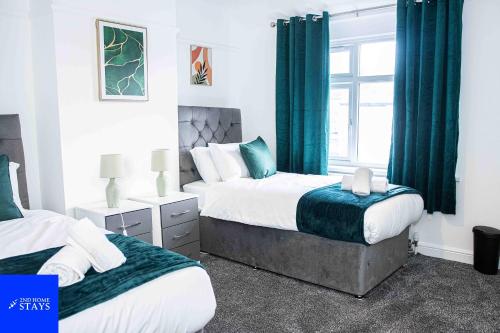 a bedroom with two beds and a window at 2ndHomeStays-3 Bedroom House - Sleeps 6 - City Centre -Stoke-on-Trent in Stoke on Trent