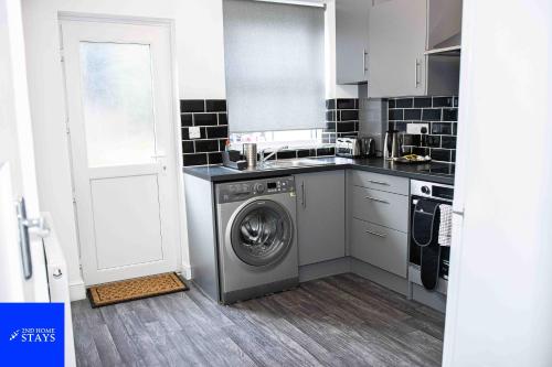 a kitchen with a washing machine in a kitchen at 2ndHomeStays- Stoke-on-Trent-A Serene 3 Bed House with a Garden View-Suitable for Contractors-Relocation Families-Group of Friends-Sleeps 6 - 16 mins to J15 M6 and 36 mins to Alton Towers Resort in Stoke on Trent
