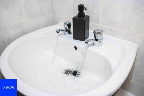 a sink with water running from a faucet at 2ndHomeStays- Stoke-on-Trent-A Serene 3 Bed House with a Garden View-Suitable for Contractors-Relocation Families-Group of Friends-Sleeps 6 - 16 mins to J15 M6 and 36 mins to Alton Towers Resort in Stoke on Trent