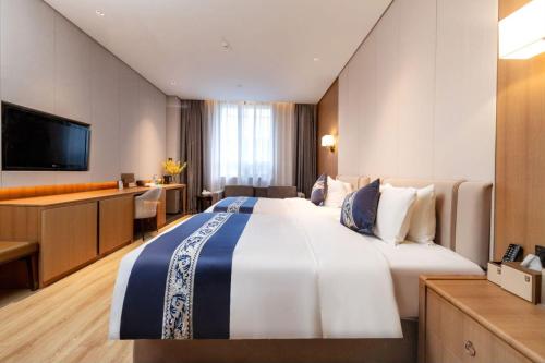 Voodi või voodid majutusasutuse Merlinhood Hotel Guangzhou Xiajiao Metro Station Shaxi International Hotel Supplies City toas