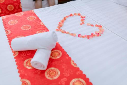 un tavolo rosso e bianco con un asciugamano e una candela di OPA HOTEL HUE a Thôn Lại Thê