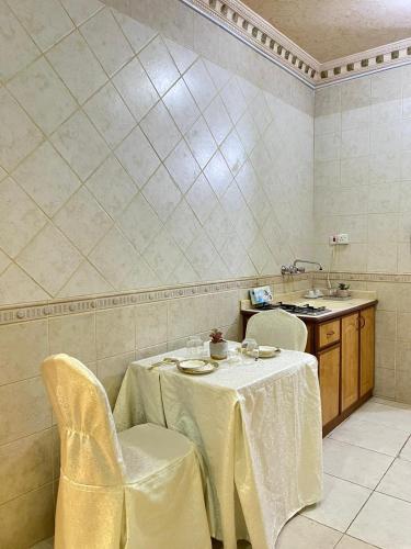 a dining room with a table and chairs and a sink at دار اليقين in Medina