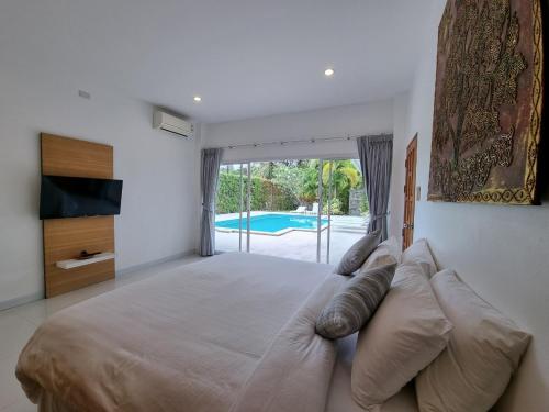 a large bedroom with a large bed and a pool at Baan Lalle in Ao Nang Beach