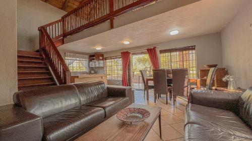 a living room with a leather couch and a table at Walking Tall Private Bush Retreat in Marloth Park